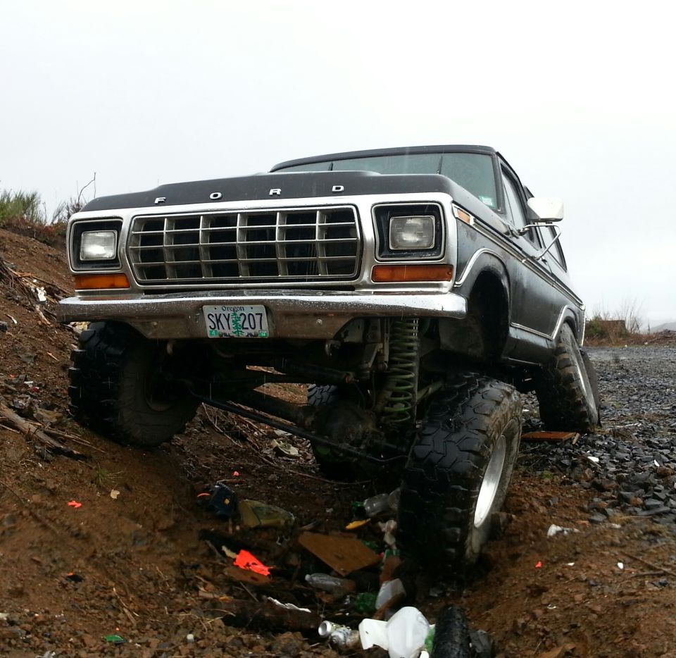 Lifted 1978 Ford Bronco with large tires on muddy terrain