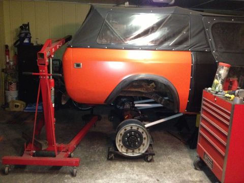 1994 Ford Bronco - An orange International Harvester Scout II is shown in a garage with a red engine hoist and a red toolbox nearby.