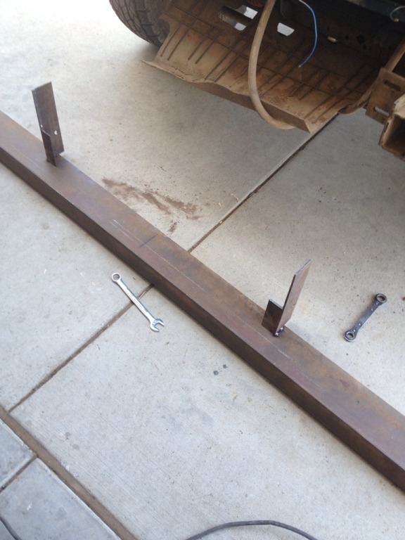 Custom bumper build with metal bar and brackets, wrenches nearby