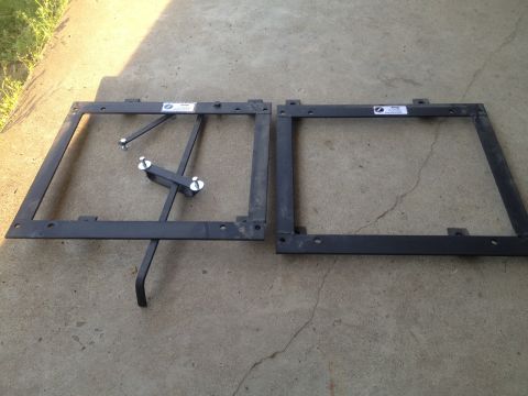 2000 Jeep Wrangler - Two metal seat frames are shown on a concrete surface, one with adjustable hardware.