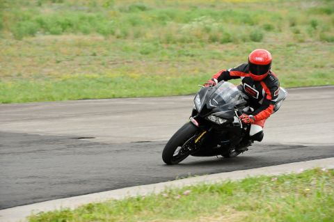 2001 Kawasaki KZ1000-A1 - A motorcycle rider takes a corner on a race track, leaning heavily into the turn.