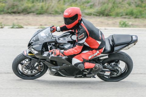 2001 Kawasaki KZ1000-A1 - A rider in full racing gear on a black sportbike, with the Supermotors logo at the bottom right.