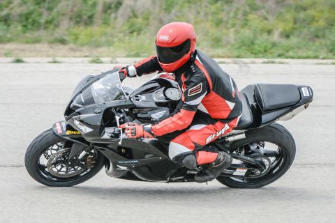 2001 Kawasaki KZ1000-A1 - Rider in full gear on a black sport motorcycle during a track day event.