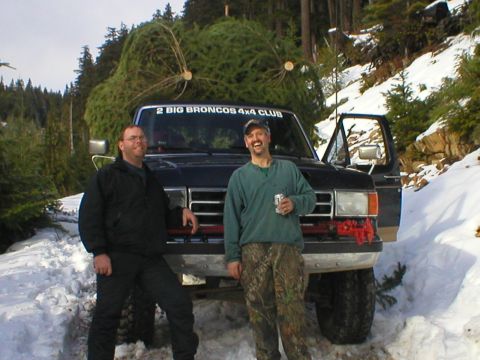 1978 Ford Bronco - Two men pose with a large Christmas tree loaded onto a Ford Bronco in a snowy, wooded environment.