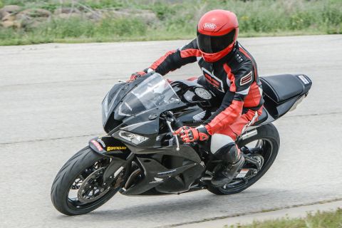 2001 Kawasaki KZ1000-A1 - A rider in full racing gear on a black sportbike, with visible Dunlop branding on the tire.