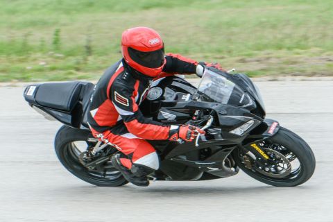 2001 Kawasaki KZ1000-A1 - A rider in full gear leans into a turn on a black sport motorcycle.