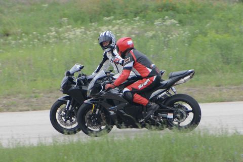 2001 Kawasaki KZ1000-A1 - Two motorcycles are ridden on a road with grassy verges.