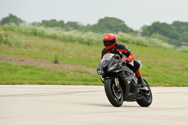 Black motorcycle with rider in red and black gear on a track