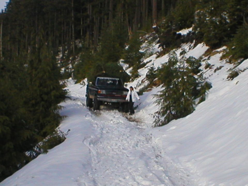 Dark pickup truck on snowy road, possibly a 1978 Ford Bronco