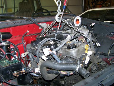 1988 Suzuki Samurai - The engine is being removed from the vehicle using a hoist and chains.