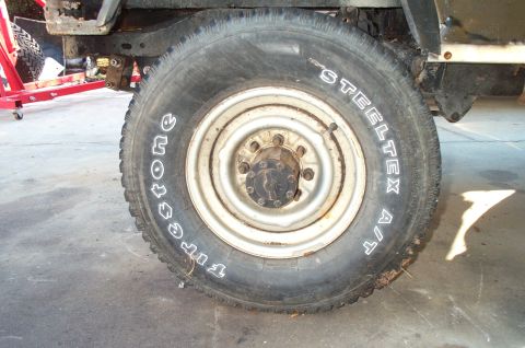 1995 Ford Bronco - A close-up view of a vehicle's tire and wheel assembly, with visible text on the tire.
