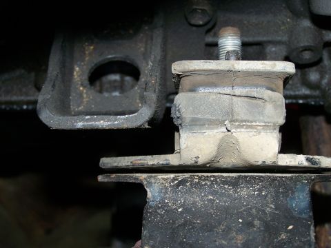1988 Suzuki Samurai - Close-up of a worn engine mount, showing damage and a visible website logo.
