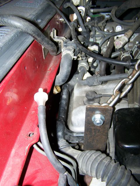 1988 Suzuki Samurai - Close-up view of an engine bay, showing various hoses, a chain, and a metal bracket. Text from a watermark is visible at the bottom.