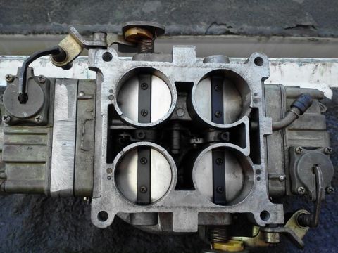 1995 Ford Bronco - This is a close-up view of a carburetor, a critical engine component for fuel delivery.