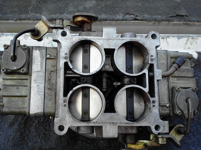 Close-up of a four-barrel carburetor with throttle plates visible