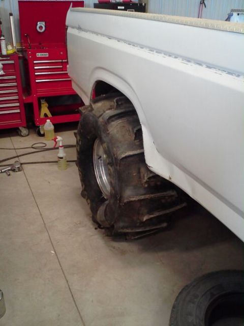 1995 Ford Bronco - White Ford Bronco with oversized mud tires is shown in a garage setting.