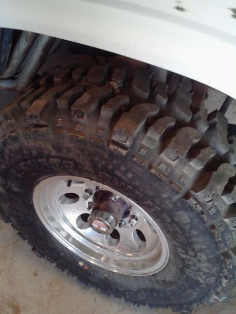 1995 Ford Bronco - A close-up view of a off-road tire mounted on a polished alloy wheel, showing the aggressive tread pattern.