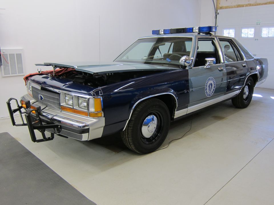 1991 Ford Crown Victoria LTD police car with hood open, blue and grey paint, push bumper, and light bar