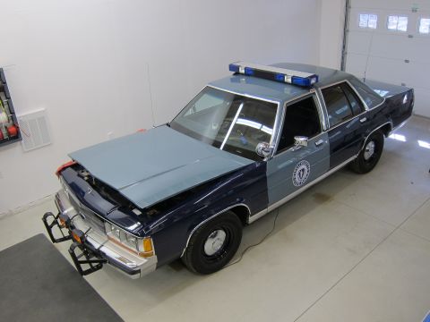 1991 Ford LTD Crown Victoria - This 1991 Ford Crown Victoria LTD police car is shown with its hood open and a light bar on the roof.