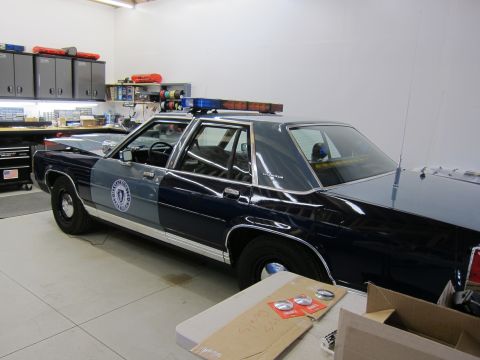 1991 Ford LTD Crown Victoria - This 1991 Ford Crown Victoria LTD police car is parked indoors, possibly in a workshop or garage.