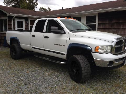1994 Ford Bronco - A white pickup truck is parked in front of a house with a gravel driveway.