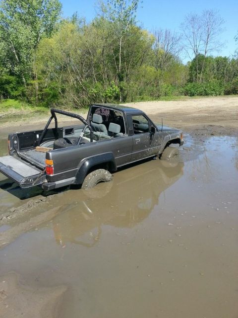 1987 Toyota 4Runner - This 1987 Toyota 4Runner is stuck deep in the mud, with its tires submerged.
