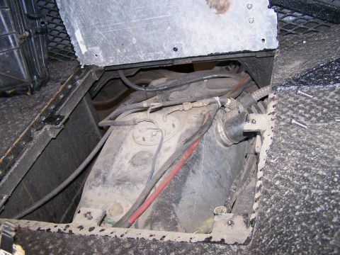 1988 Suzuki Samurai - Close-up view of the fuel tank and associated lines, likely from the underside of a vehicle.