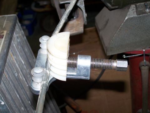 1988 Suzuki Samurai - Close-up of a tube bending tool, white rollers and a threaded adjustment rod.