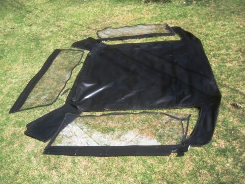 1993 Ford Bronco - Soft top and windows for a vehicle, spread out on a grassy surface.