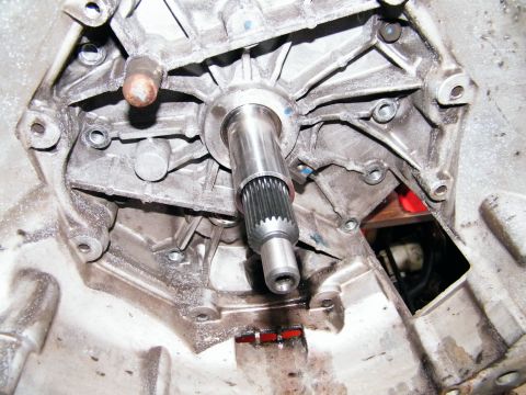 2004 Ford Crown Victoria - Close-up of a transmission housing, showing a splined shaft extending from the center. The part is dusty and shows signs of wear.