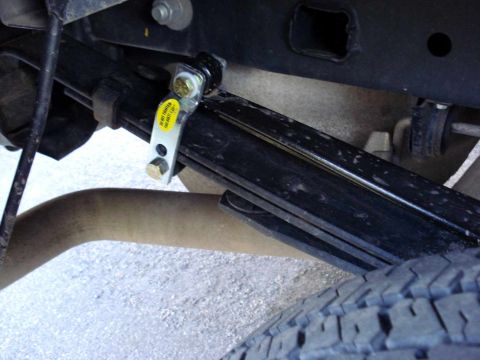 2008 Ford Crown Victoria - Close-up view of a vehicle's leaf spring assembly and exhaust pipe.