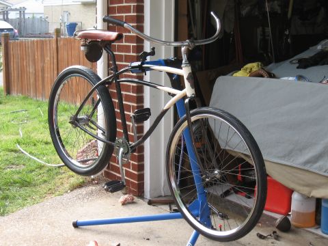 1994 Ford Bronco - A bicycle is mounted on a repair stand in front of a brick wall and garage.