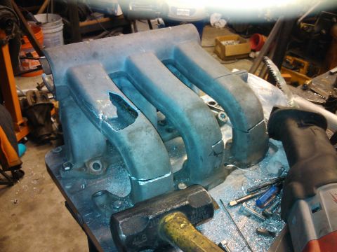 1995 Ford Probe - This intake manifold appears to be damaged and is on a workbench with tools.