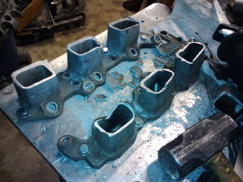1995 Ford Probe - This is a modified engine intake manifold with its ports cut open, resting on a workbench with metal shavings.
