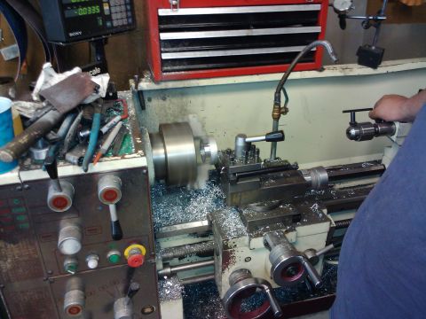 1995 Ford Probe - A metalworking lathe is in operation, with a person's hand visible on the drill chuck.