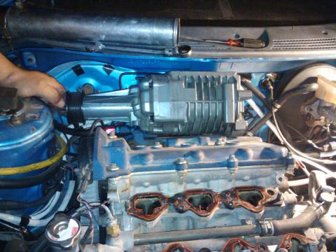 1995 Ford Probe - A supercharger is being installed onto a vehicle's engine, with various hoses and parts visible.