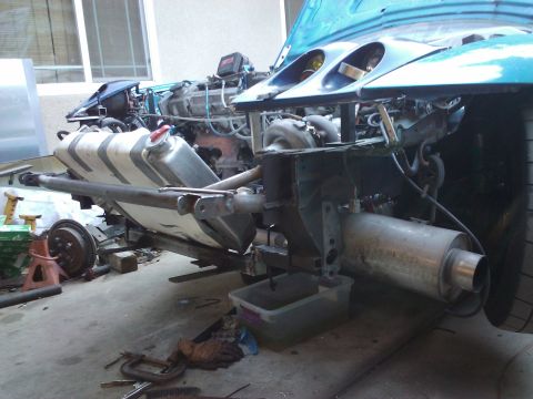 1995 Ford Probe - The front section of a disassembled vehicle reveals its engine, fuel system, and exhaust components.