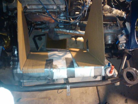 1995 Ford Probe - Cardboard is used to protect engine components and the radiator during work in the engine bay.