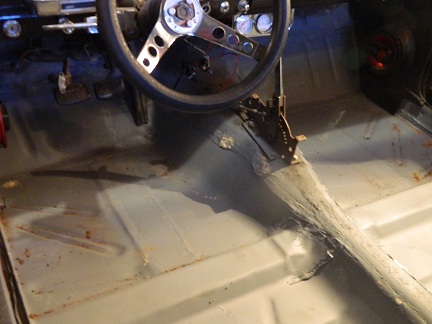 1962 Ford Ranchero - The interior of a 1962 Ford Ranchero displays a worn floor, steering wheel, and shifter mechanism.