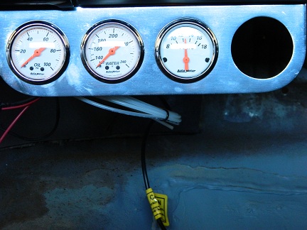 1962 Ford Ranchero - A close-up of a vehicle's dashboard shows oil, water, and voltage gauges, along with an empty space.