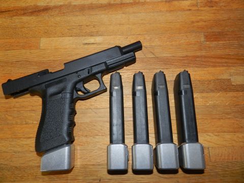 1996 Ford Bronco - Glock pistol and extended magazines laid out on a wooden surface.