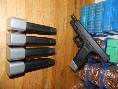 1996 Ford Bronco - A Glock pistol and several magazines are laid out next to boxes of ammunition on a wooden surface.