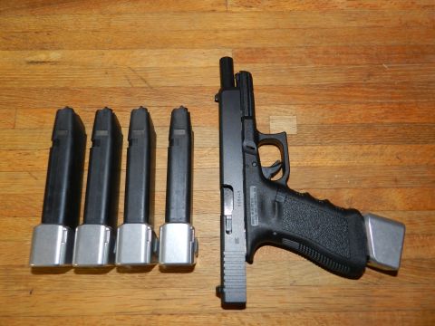 1996 Ford Bronco - A Glock pistol is displayed with four extended magazines, all resting on a wooden surface.