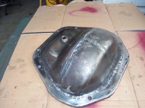 1968 Ford Bronco - Welded differential cover with a plug, resting on cardboard.