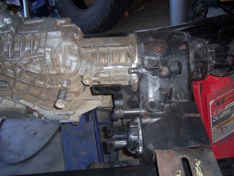1968 Ford Bronco - This image shows a close-up view of a vehicle's transmission and transfer case assembly, likely undergoing modification or repair.