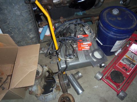 1968 Ford Bronco - Various automotive parts and tools are laid out on the floor, possibly for a repair or restoration project.