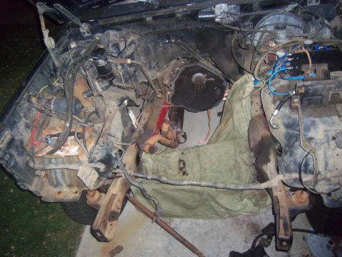 1968 Ford Bronco - The engine bay of a 1968 Ford Bronco is shown with the engine and transmission exposed for repair.