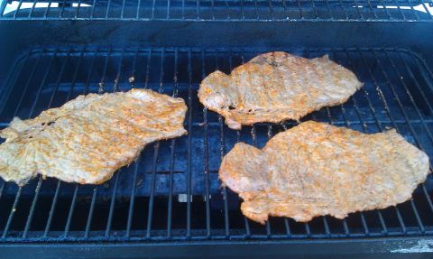 1989 Ford Bronco - Seasoned flank steaks are grilling on a barbecue.