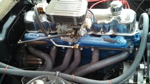 1966 Ford Falcon - Close-up view of a vehicle's engine compartment, highlighting the intake manifold and exhaust system.