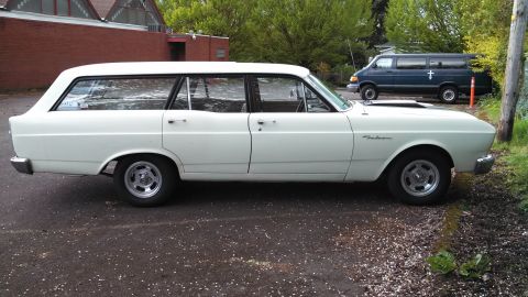 1966 Ford Falcon - Side view of a white 1966 Ford Falcon wagon with aftermarket wheels.